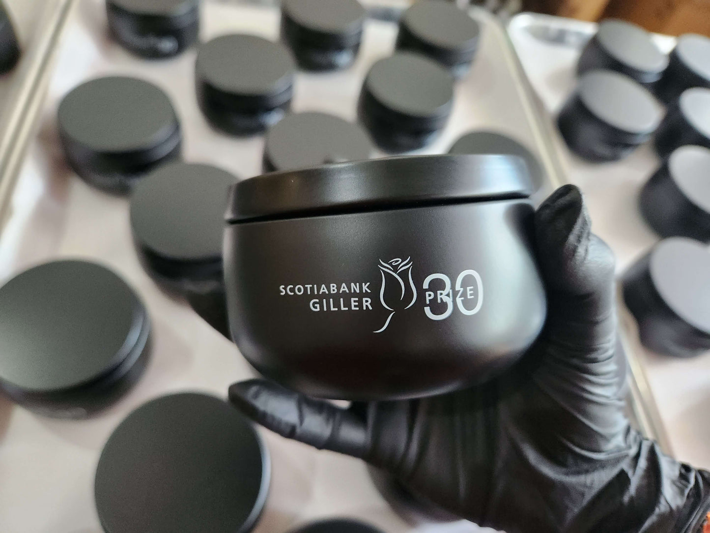 Candle factory production of a custom 8oz black tin candle with logo imprint for corporate gifts